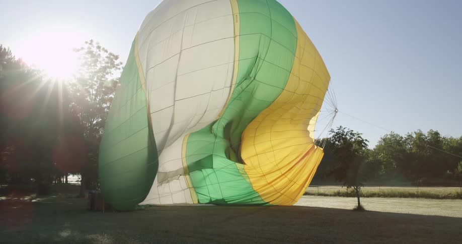 Men filling a striped hot air balloon