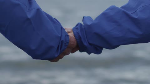 A couple taking hold of each other's hand, then letting go