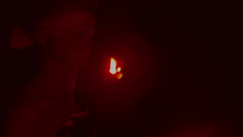 A flaming torch shines on a statue
