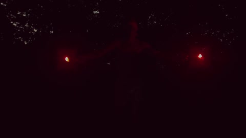 A person holding flares and slowly raising them in the air
