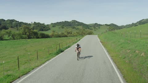 Man bikes down a country road