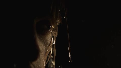 Close up view of water dripping off the head of a man who is staring off into the distance