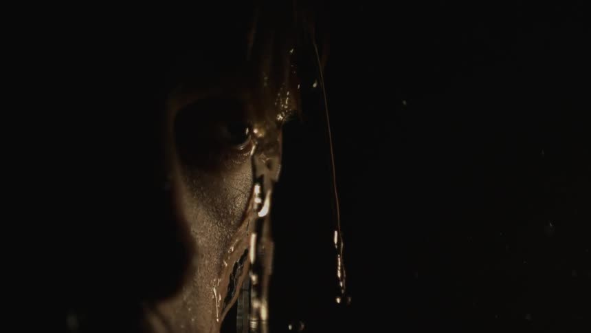 Close up view of water dripping off the head of a man who is staring off into the distance