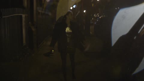 A dressed up woman is running, stops, turns back and runs again while looking over her shoulder