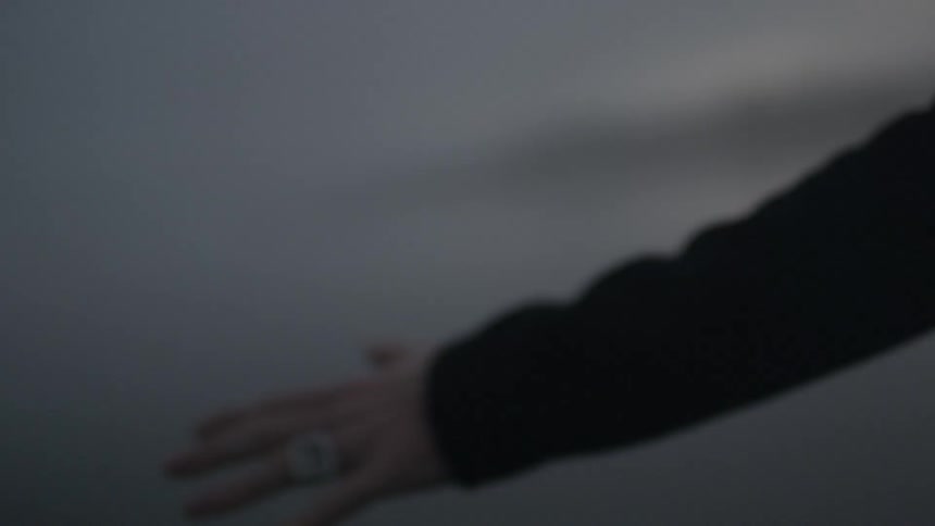 A hand reaches out into the air