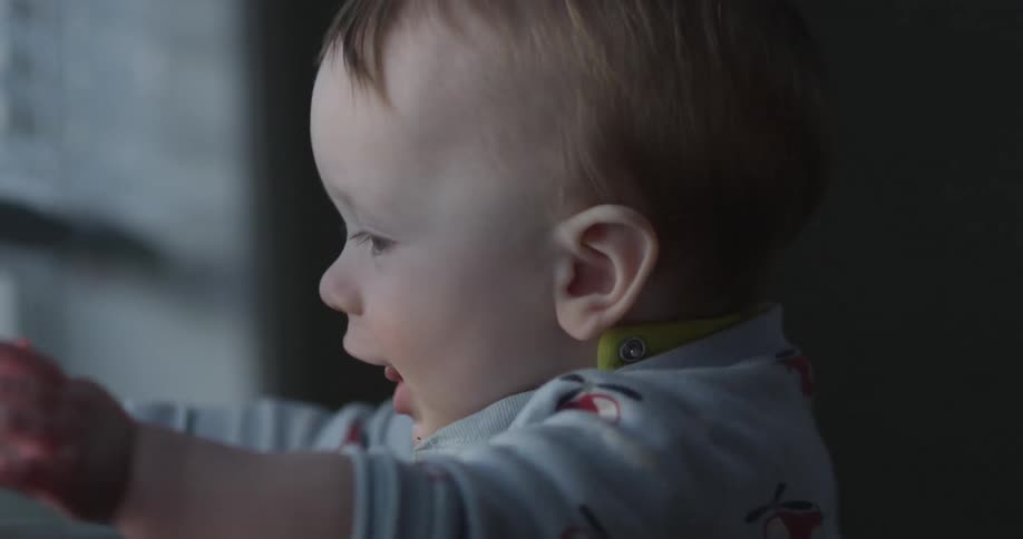 Baby plays with window blinds