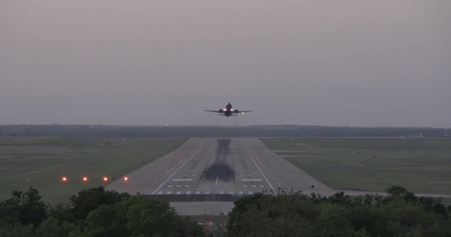 An airplane going down the runway and taking off