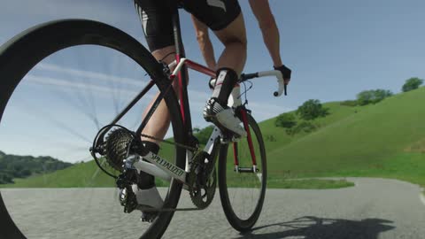 Bicyclist rides along paved bath on a sunny day