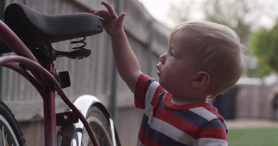 Toddler plays with an adult bike
