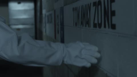 Person in a while suit, with white gloves touches the wall