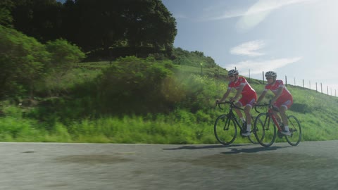 Two people in red bike on a street