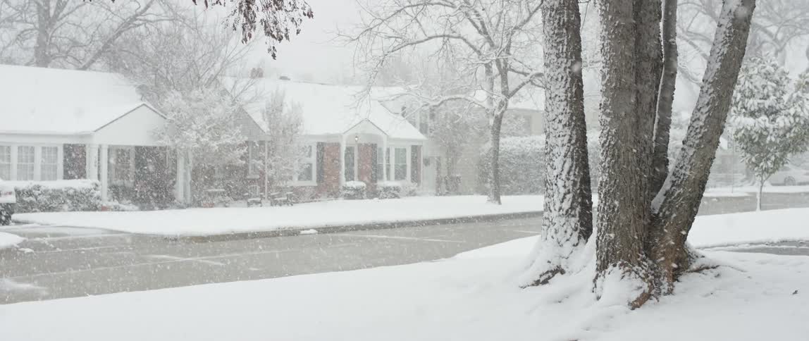 Snow falling in front of a house
