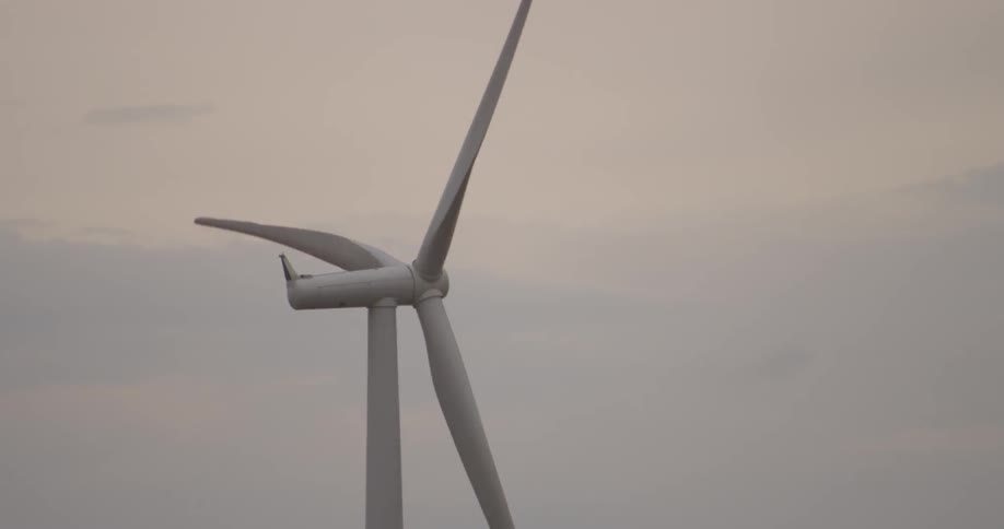 Spinning wind turbine against a cloudy sky