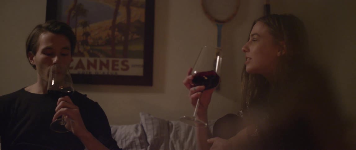 A young couple toasting with glasses of wine