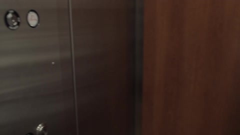 An astronaut walks into an elevator and pushes a button
