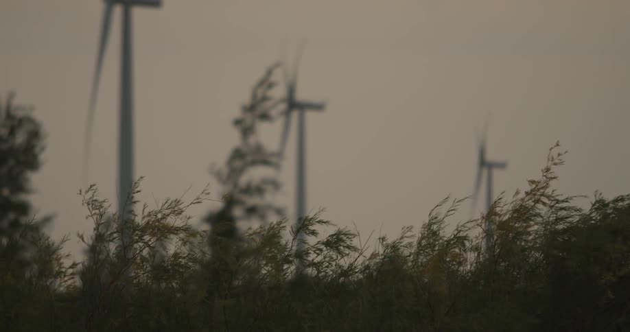 Several wind turbines spinning as the wind blows