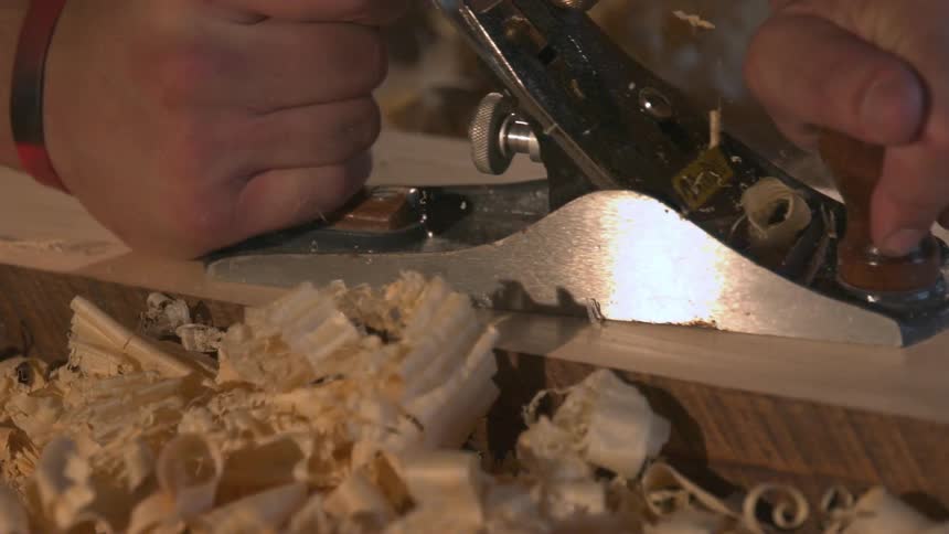 A person shaving wood