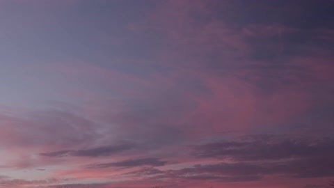Blue and pink clouds slowly pass by, speeded up with timelapse