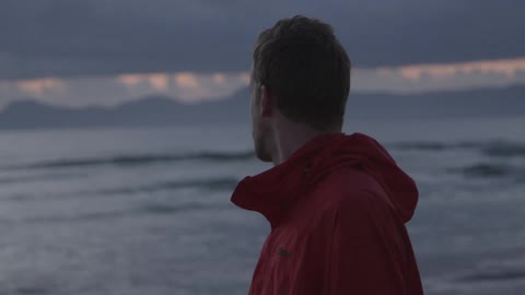 Man standing on the beach looking at the water