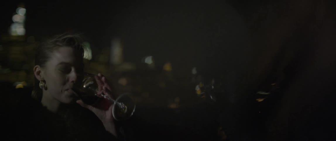 Man and woman drink wine outside at night