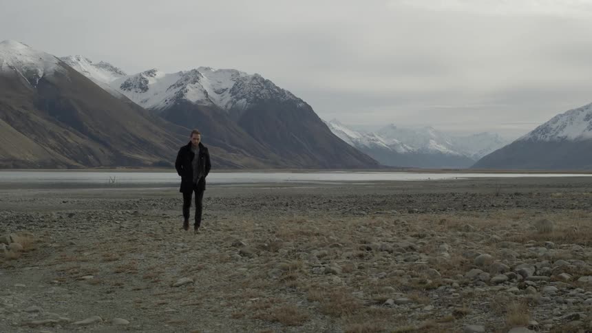 A person walking away from a mountain
