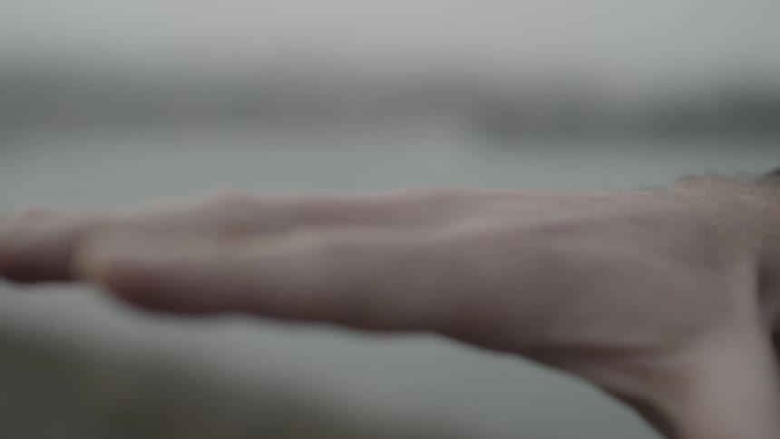 A man wiggles his hand in the air
