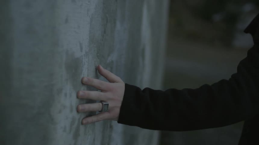 A person touching a wall as they walk past