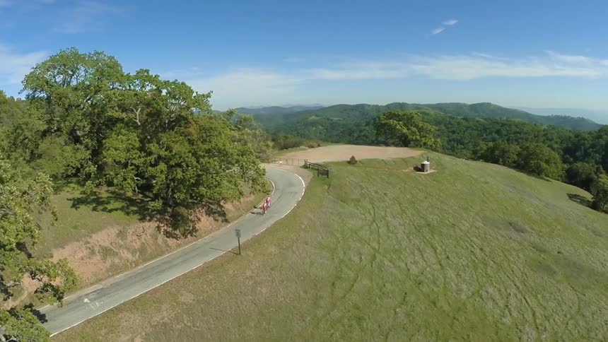 Aerial view of a two cyclist cycling on the countryside road