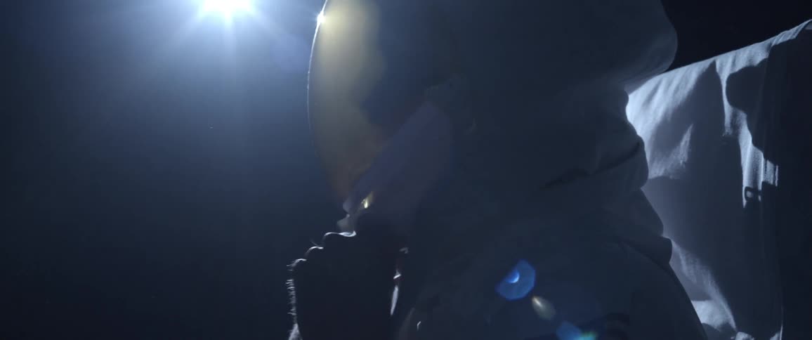 A man puts on and adjusts an astronaut helmet