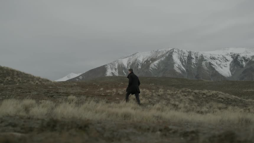 A person walking in a valley of a mountain range