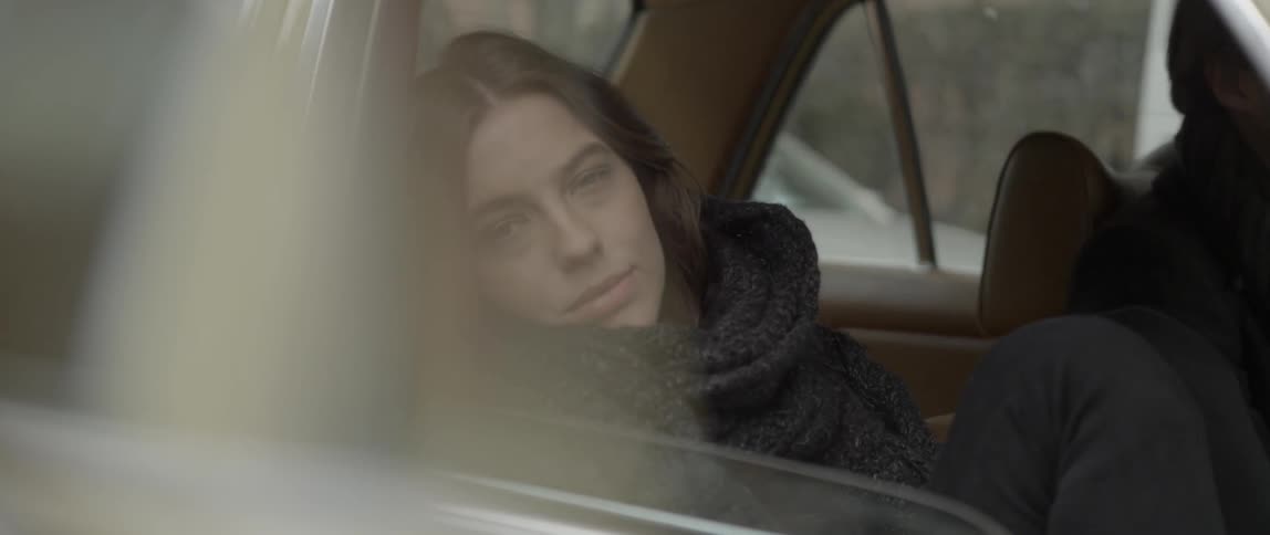 Woman sitting in car smiles