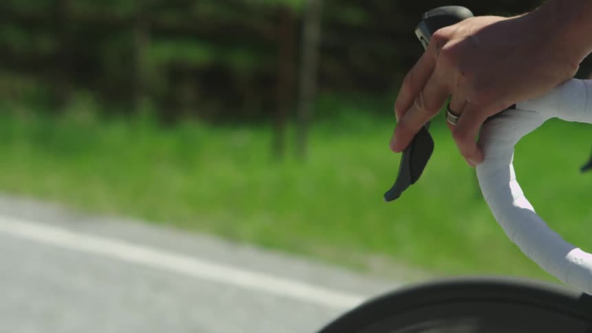 A man riding a ten speed on a road in a rural area