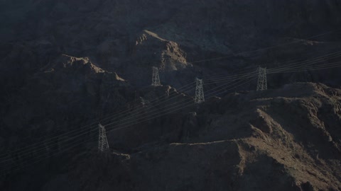 A view of electric lines and towers that are located on top of mountain cliffs