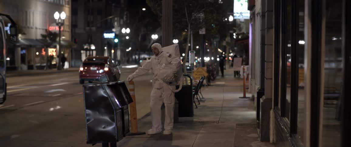 An astronaut casually stands by a busy city street