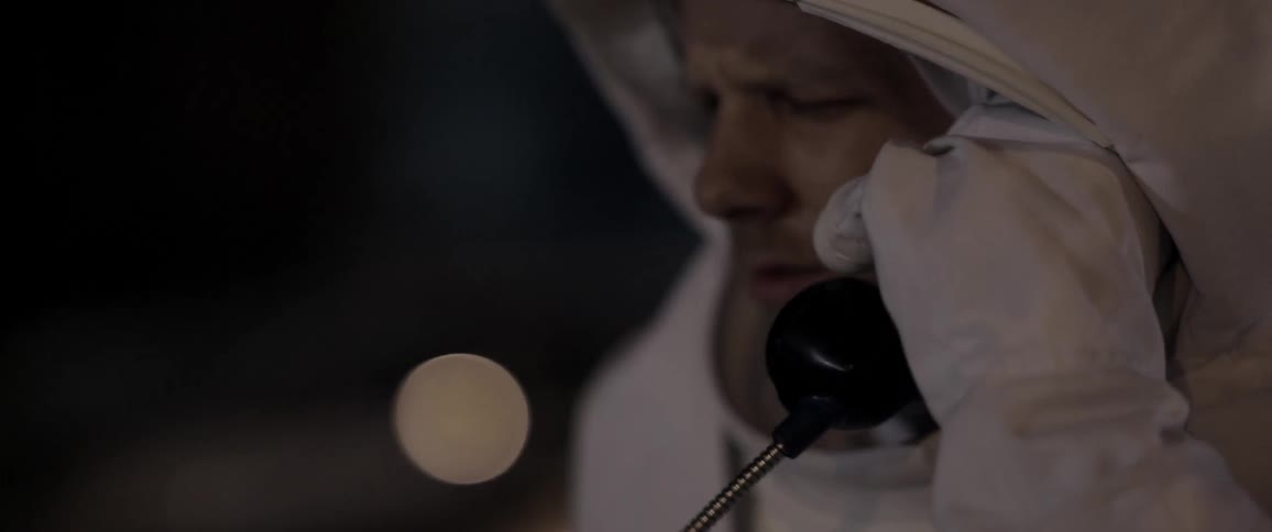 A man dressed as an astronaut talking on a phone