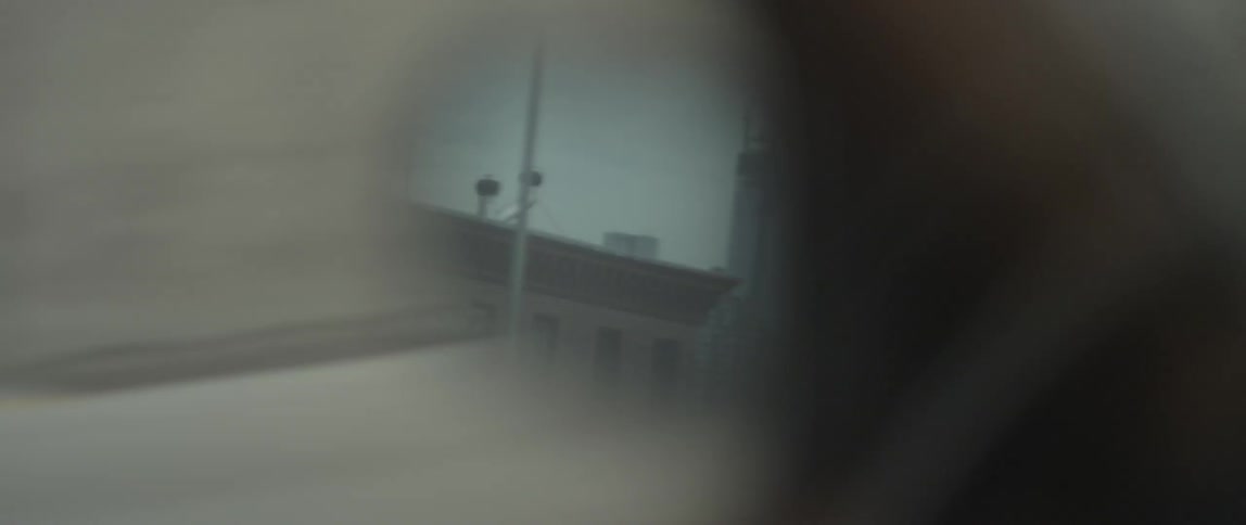 Rear view mirror showing the buildings as they are being passed
