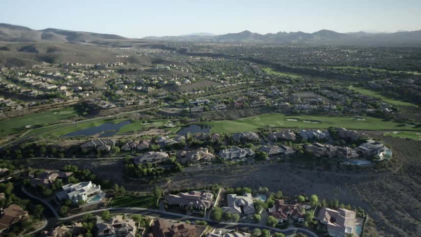 A helicopter view of a town predominantly hilly and grassy
