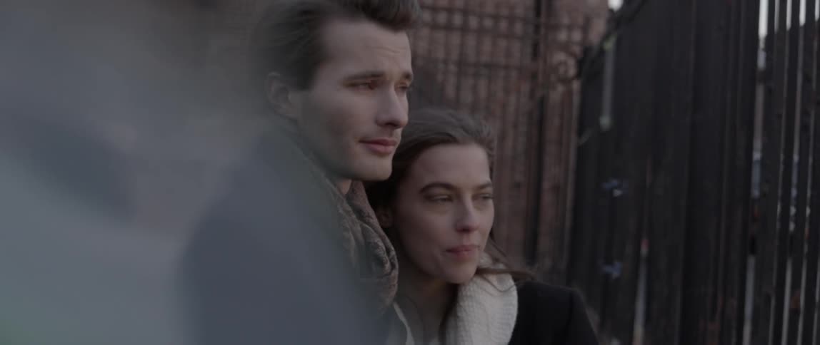 A young adult couple look on towards the viewer's perspective