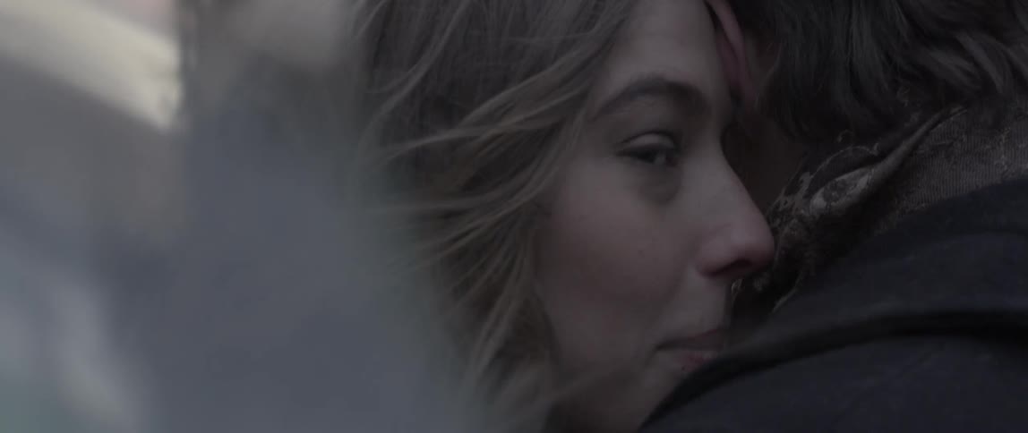 A woman hugs a man while speaking to him