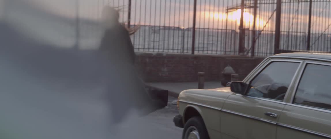 Man and woman getting out of a car and walking towards a sunset