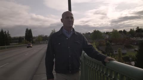 A man walking on a sidewalk of the road