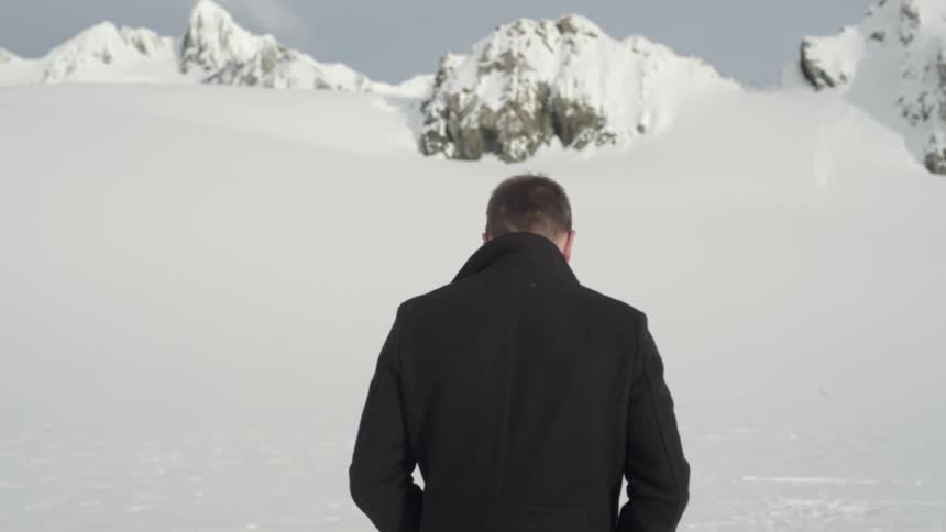 A person stands before a ice cliff