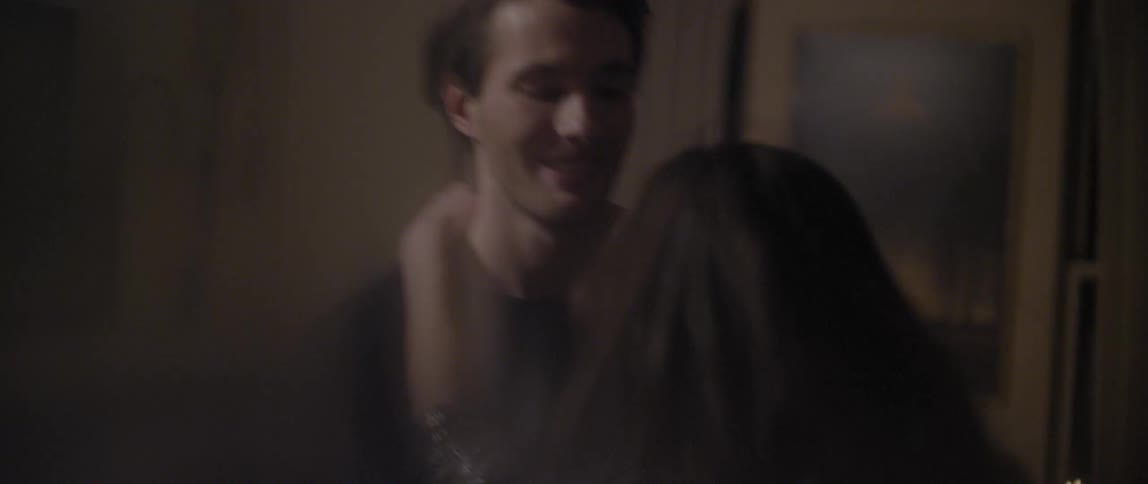 A man and woman in their 20s dancing happily in a living room
