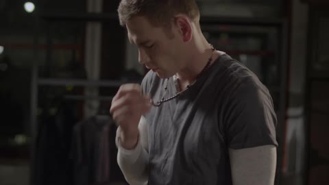 A man kisses a necklace before removing it and his clothing