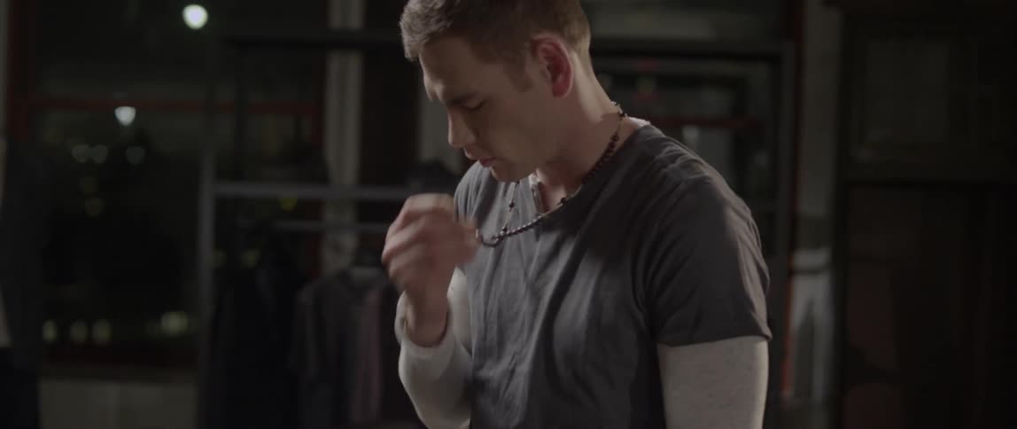 A man kisses a necklace before removing it and his clothing