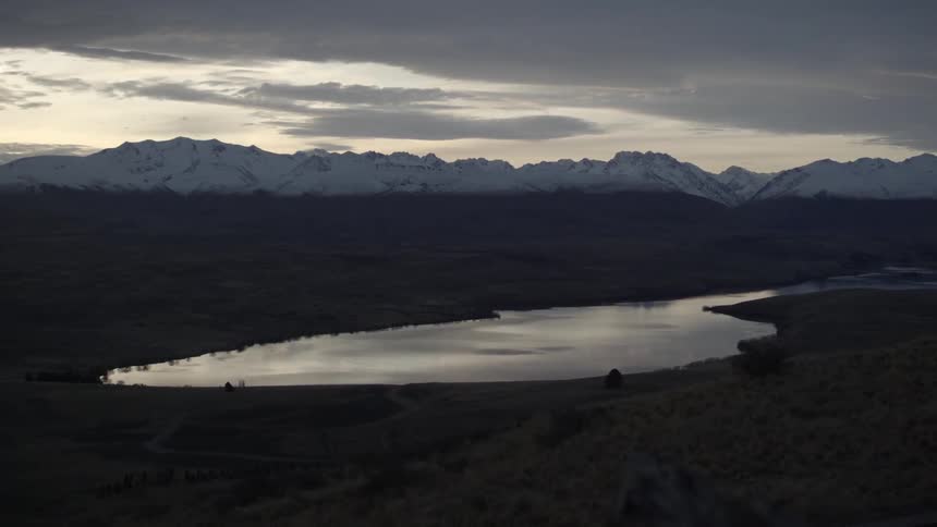 Serene lake in front of mountains on a cloudy day