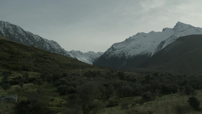 Desolate area in front of snow capped mountains