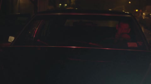 During the rain, a man drives his car at night
