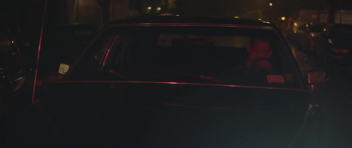 During the rain, a man drives his car at night