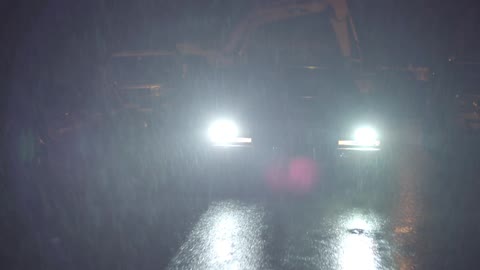 A car driving at night in the rain